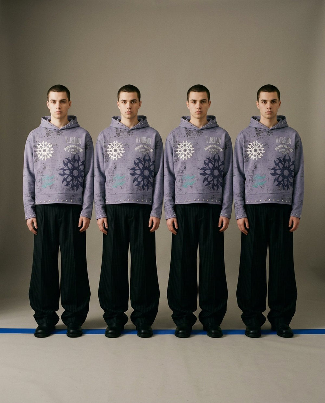 Four identical men in a lavender Dissorder hoodie standing on a blue line